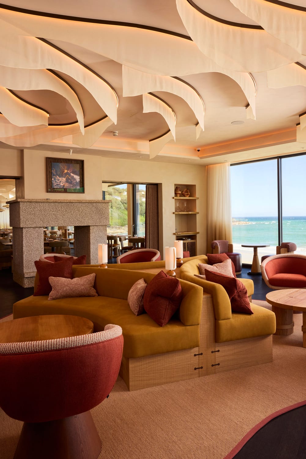 Lounge banquettes and granite fireplace at MOR Carbis Bay
