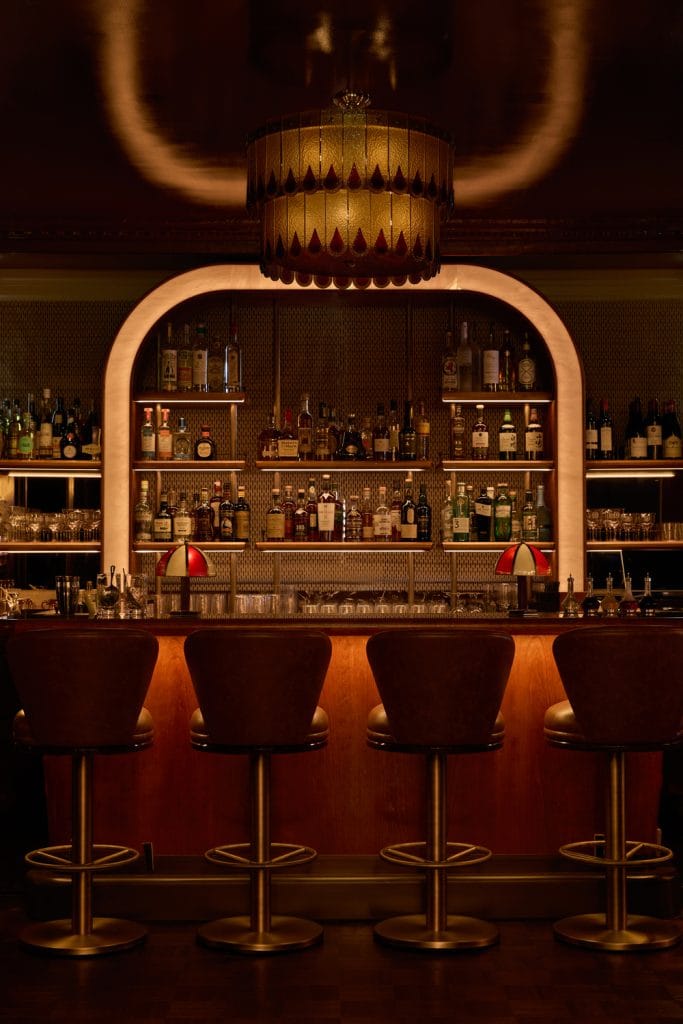 Illuminated arched back bar and bar stools at Simpson's Bar, London